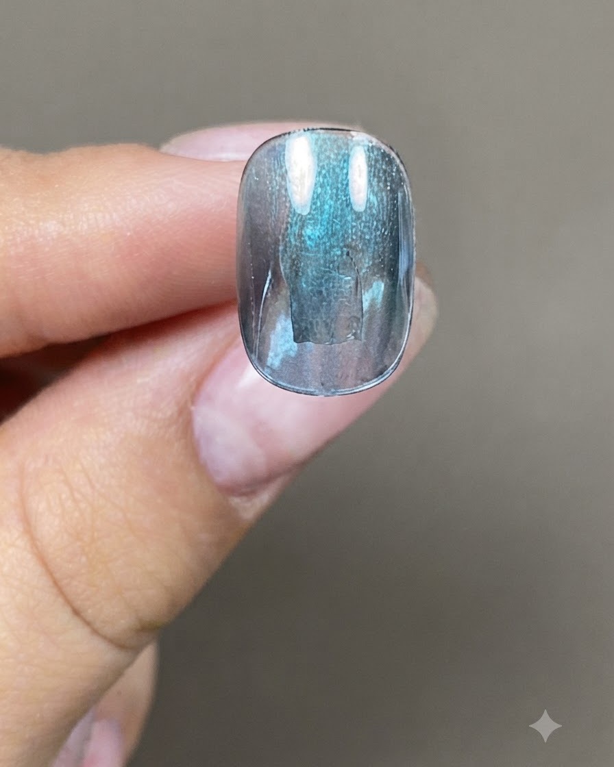 ネイルブラシを使ってブルーグリーンのキャッツアイジェルを厚めに塗っている様子。