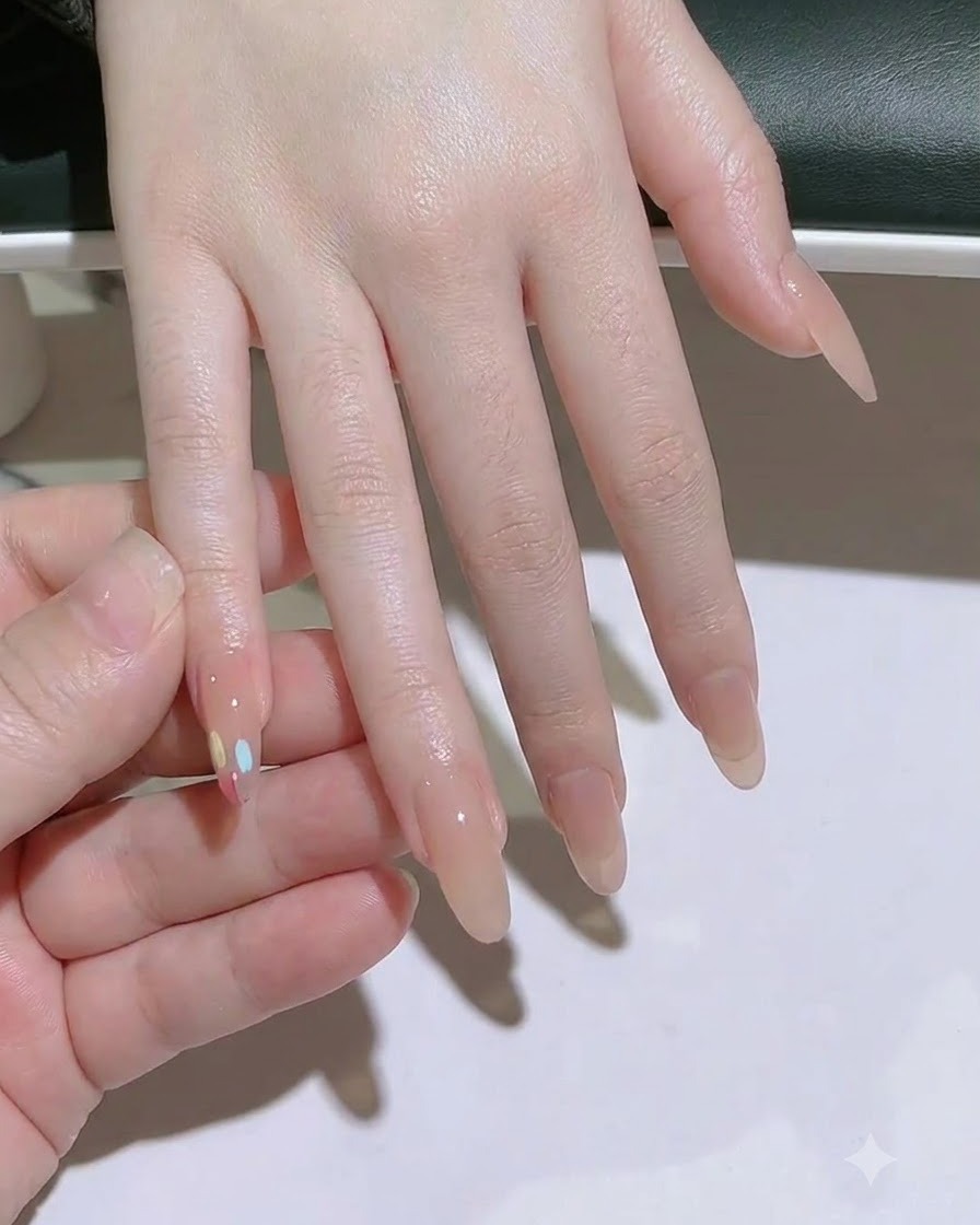 ワイプを使って中指のネイルプレートを綺麗に拭き取る様子。