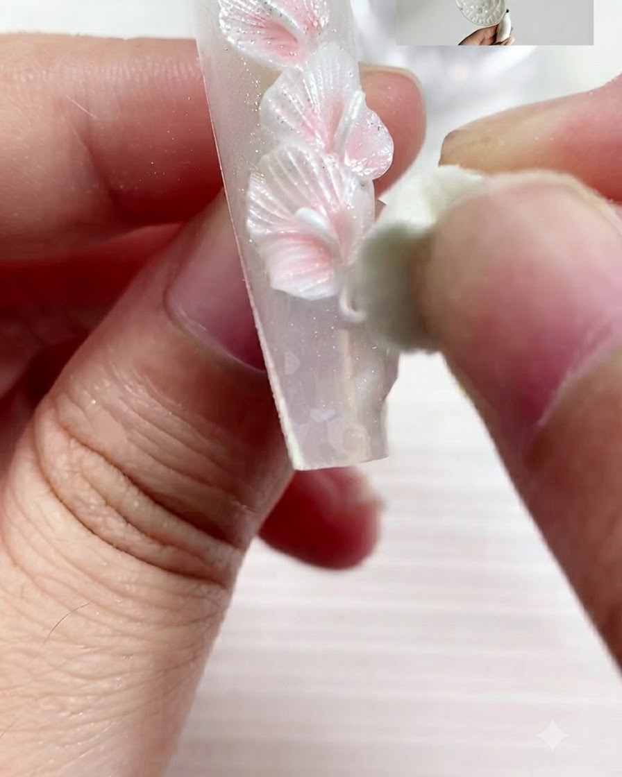 彫刻ツールを使って、ジェルの塊を押しつぶし、平らなカラーリリーの花びらの形に整えている様子。