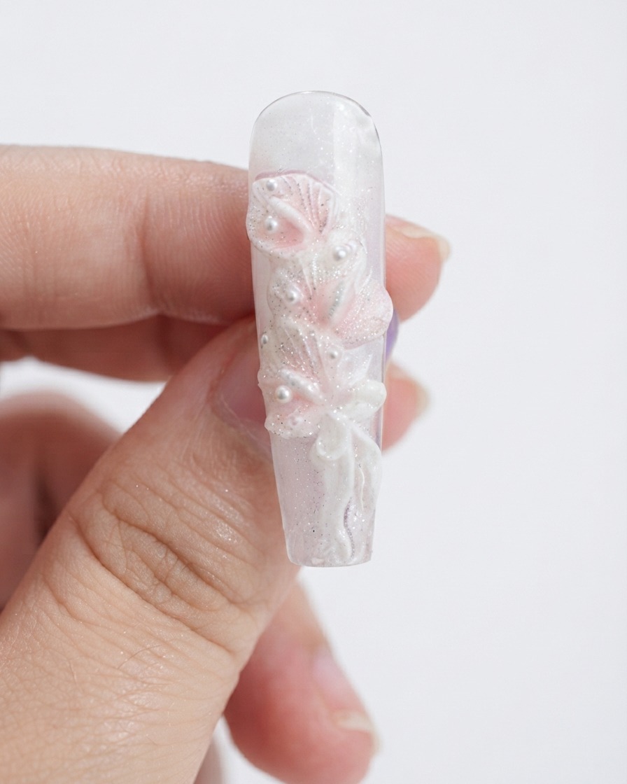 メイク用スポンジを使って、形を整えた白いカラーリリーの花びらにライトピンクのジェルを軽く叩き込んでいる様子。