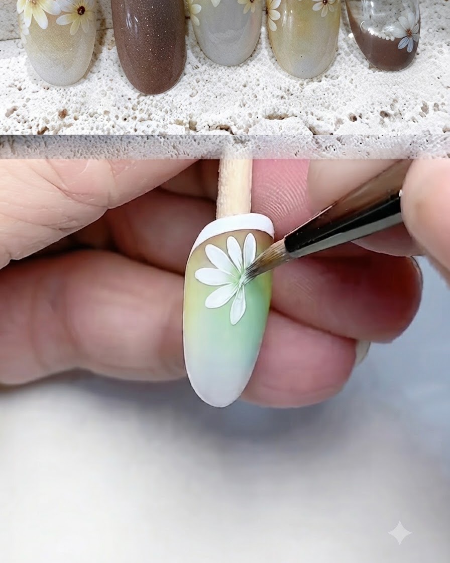 グラデーションネイルの先端に、極細ライナーブラシで白いデイジーの花びらを丁寧に描き込んで定義している様子。