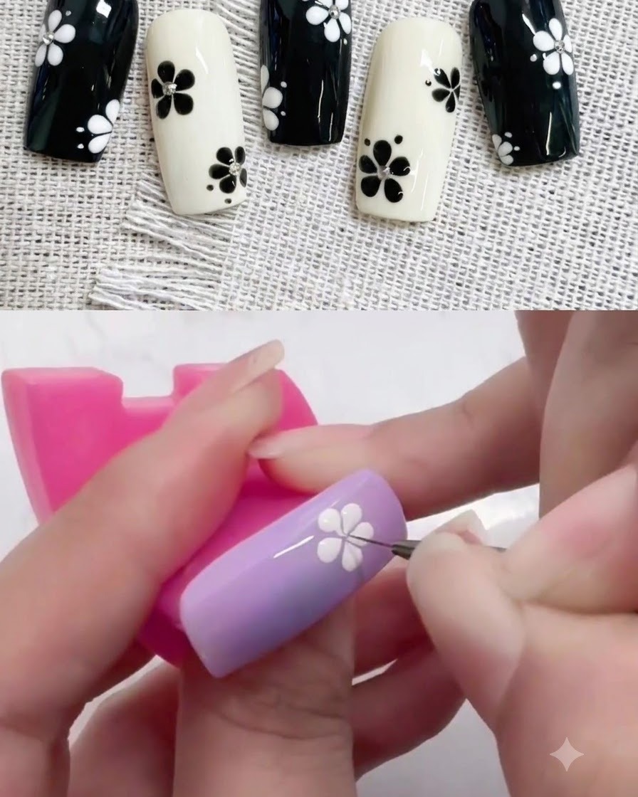 紫色のネイル上の白い花のデザインに、小さなドットペンを使って黒い中心のドットを置いている様子。