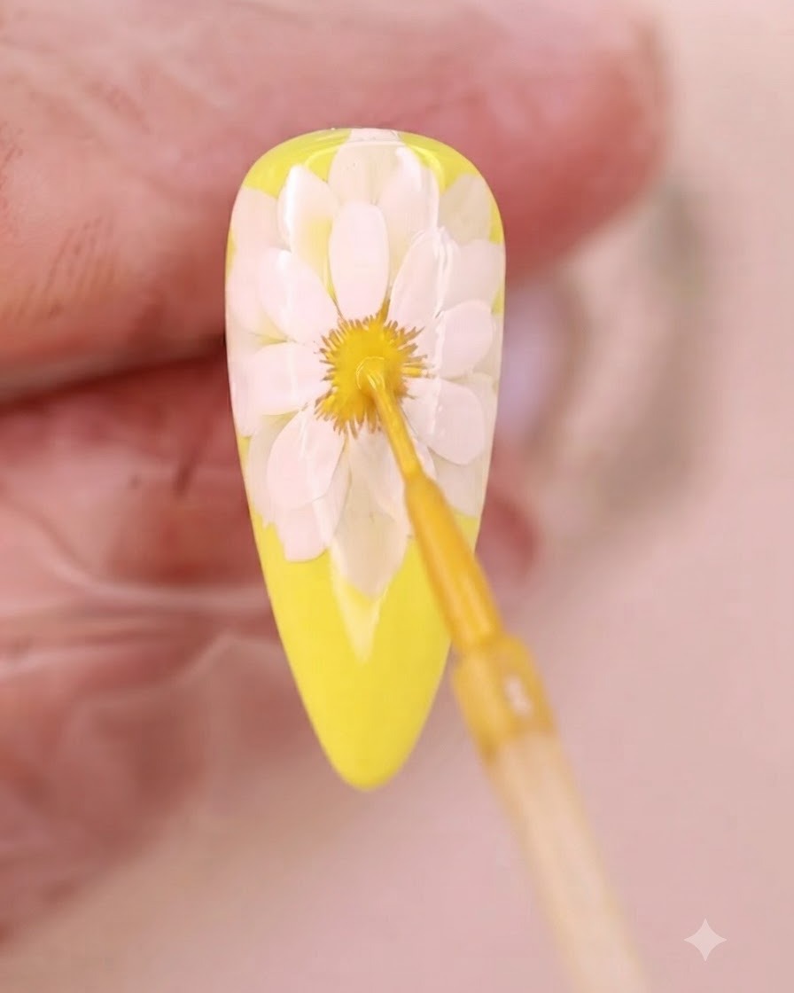 花のブルーミング中心部に、極細ブラシでイエローのリキッドを塗っている様子。