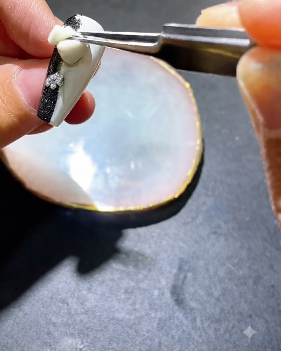 ツールまたはブラシが装飾された爪の側面に黒いジェルポリッシュを塗布している様子。