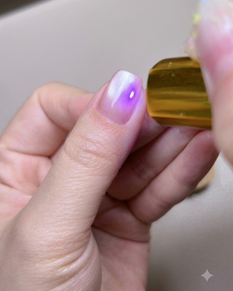 ポータブルなゴールドのUV LEDライトの下に親指が置かれている様子。
