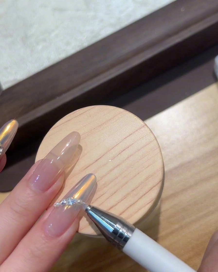 ネイルアートの宝石を硬化させるため、コンパクトなUV/LEDランプの下に置かれている指。