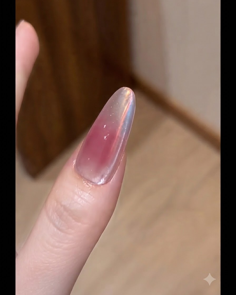 フラットブラシを使用して、長さ出ししたネイルの表面にヌードカラーのジェルを薄く均一に塗布している様子。