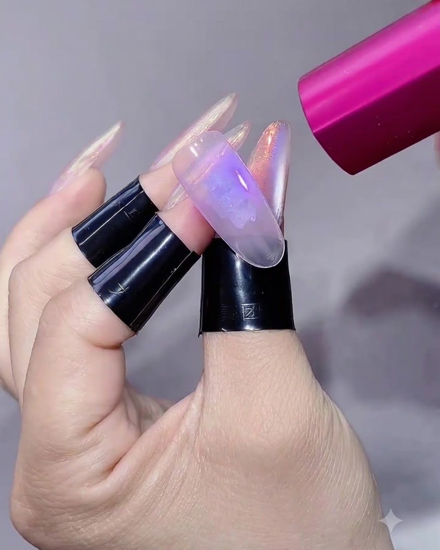 ピンク色のハンディUV/LEDランプの光を長さ出ししたネイルに照射している様子。