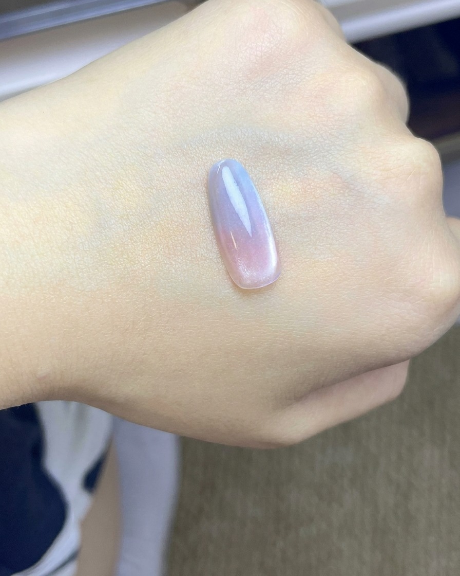 ピンクのチークグラデーションが施され、UV/LEDランプの下で硬化しているネイルチップ。