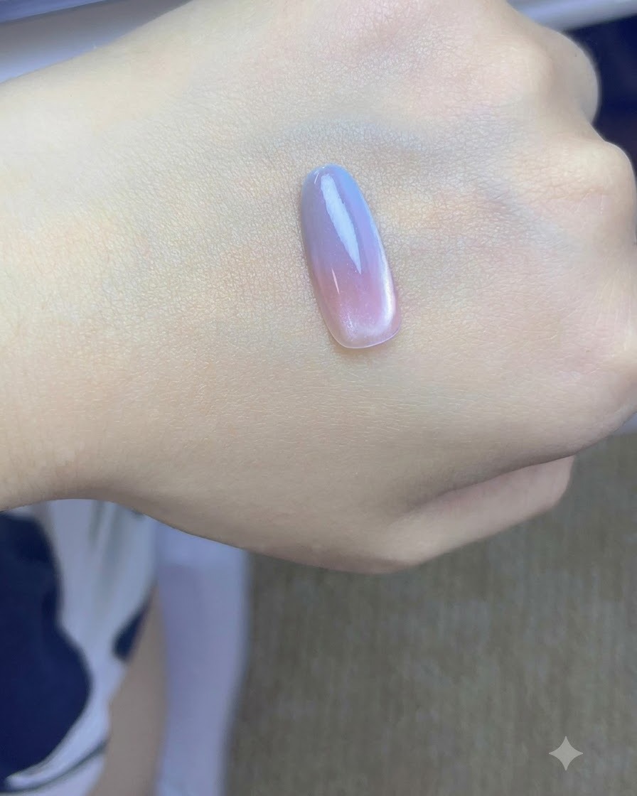 ピンクとブルーのグラデーション層が施され、UV/LEDランプの下で硬化しているネイルチップ。