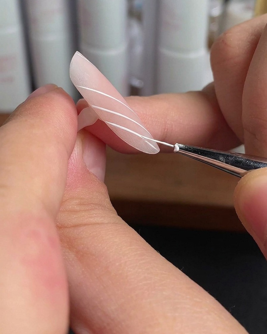 白い平行線が描かれた薬指がランプの光の下で硬化されている様子。