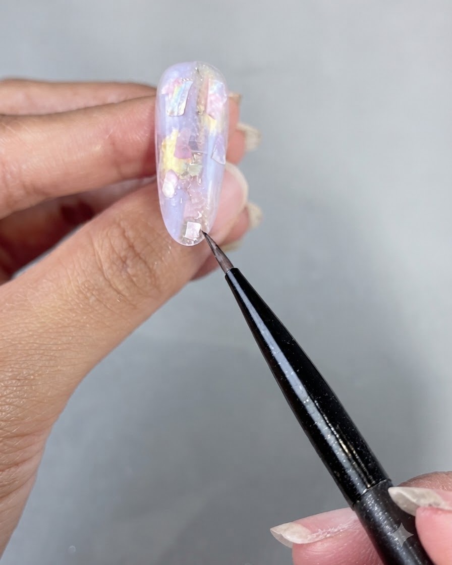 適用されたシェルパーツとビルダージェルを硬化させているUV LEDネイルランプの下に置かれた手。