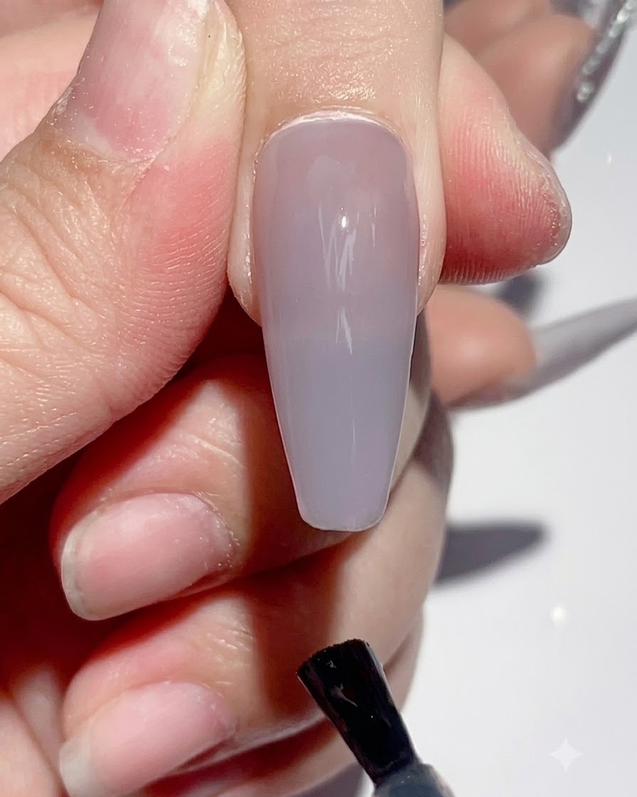 硬化プロセス中にUV/LEDネイルランプの下に置かれた手。