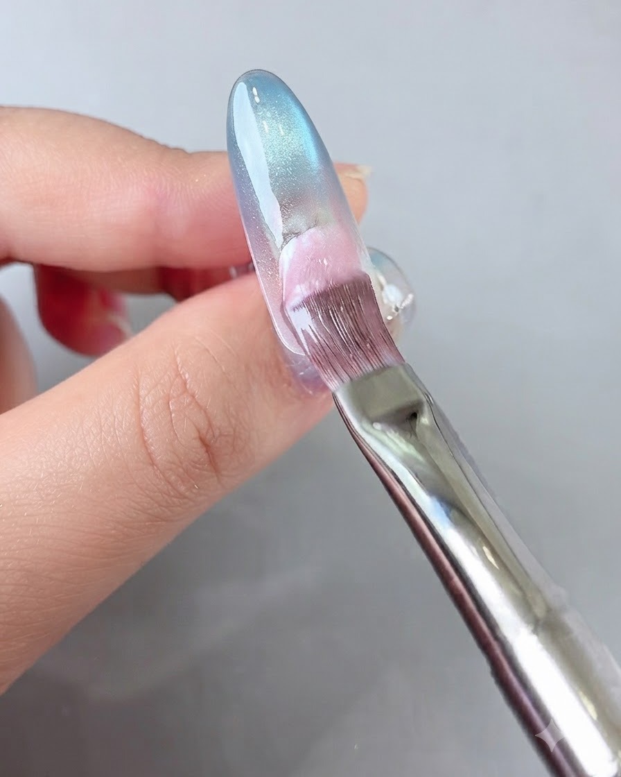 爪のベース部分(根元側)にピンクのジェルをブラシで塗布している様子。