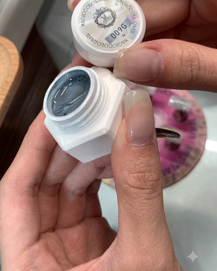 塗布の準備が整ったネイルの横に置かれた、キャッツアイジェル 009のボトル。