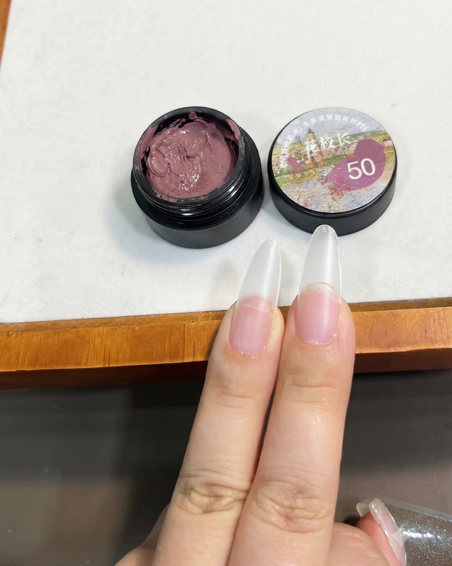クリアネイルの先端に少量の小豆ピンクのソリッドジェルをブラシで載せている様子。