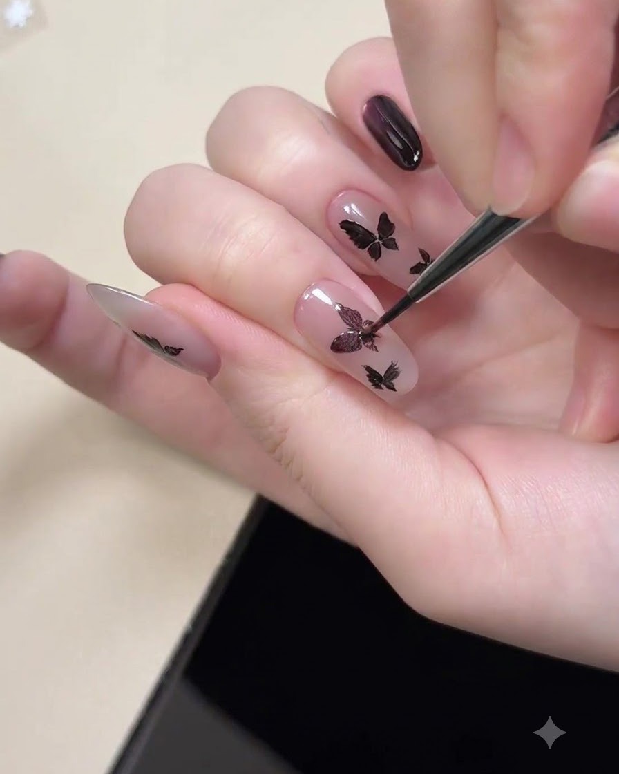 塗装された黒の蝶の形状の内側にあるパープルキャッツアイのシマーを磁化するために、爪の近くにかざされたマグネットツール。