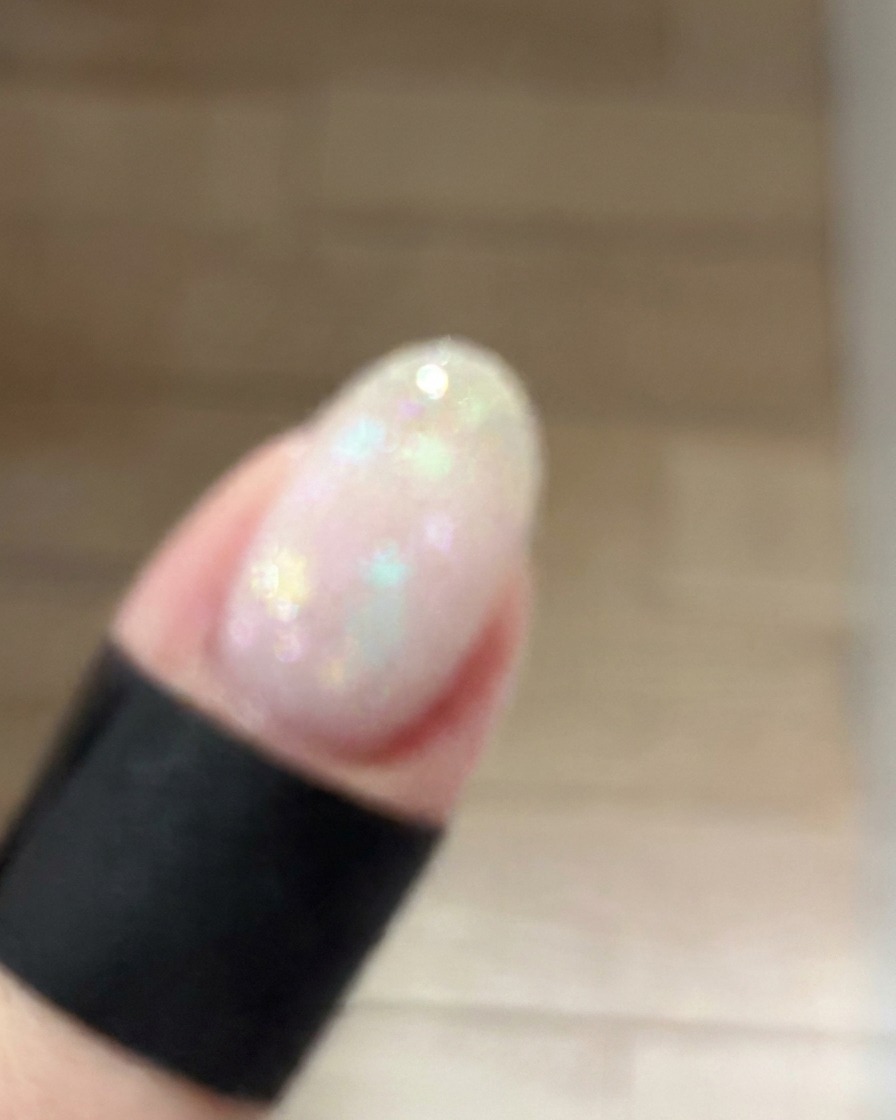 ふんわりとしたチークグラデーションを作るため、小さなメイクスポンジで爪の中央にダスティピンクのジェルを優しく叩き込んでいる様子。