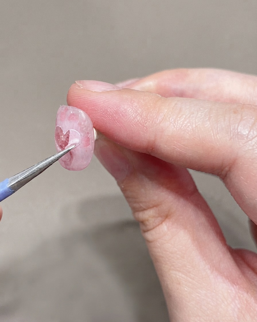 下準備されたネイルに、極細のブラシでごく薄いピンクのジェルポリッシュの2度塗りをしている様子。
