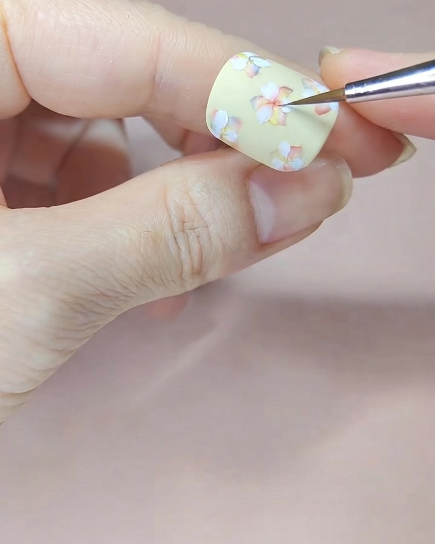 他の白いお花の中心にも赤い水彩絵の具を丁寧にのせて陰影を深めている手元。
