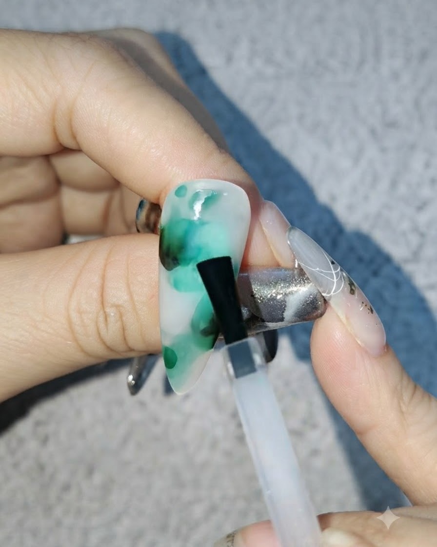 小さな黒いカラーのドットを、既存のグリーン色のブルーミングパターンに細筆でブレンドしている様子。