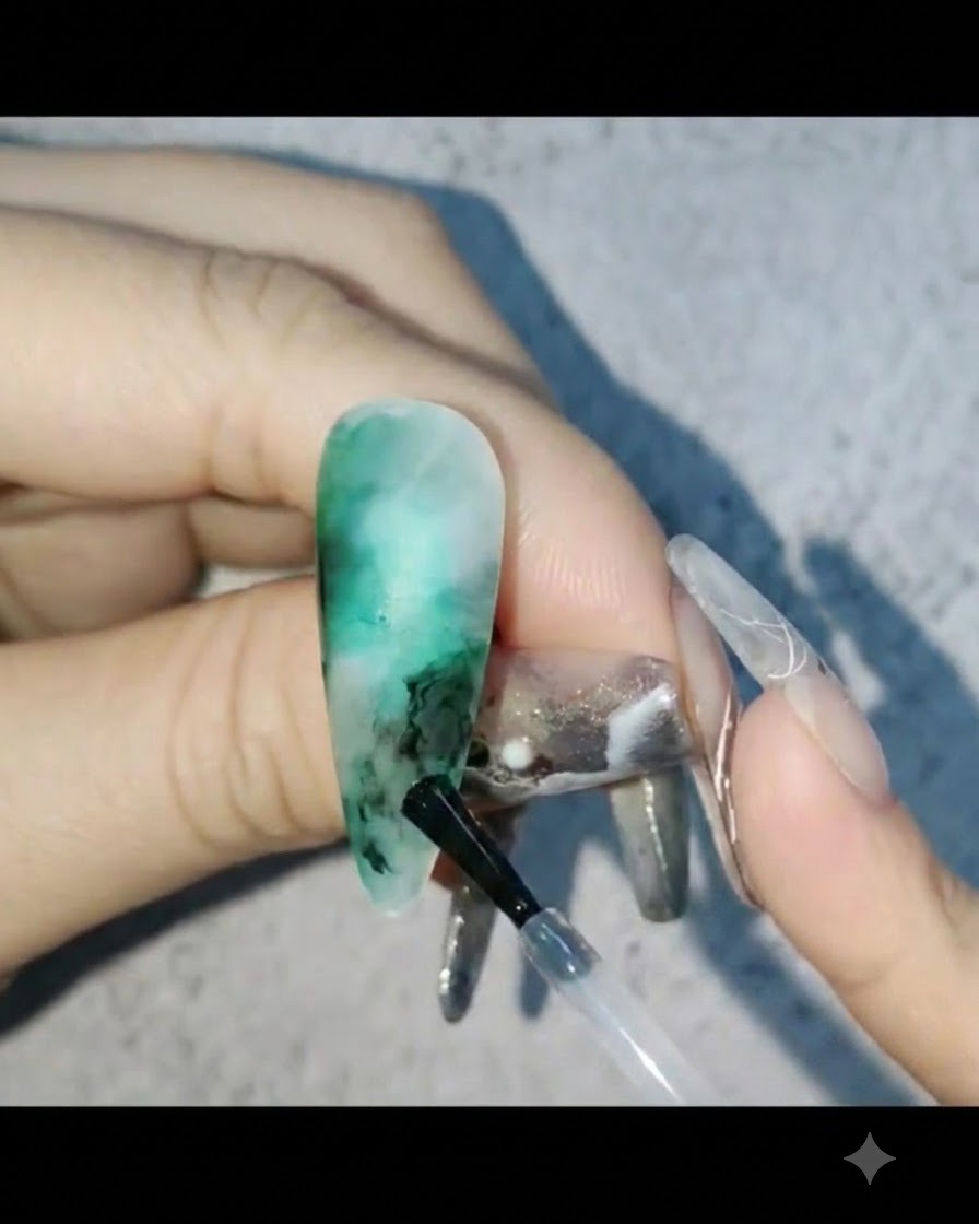 ネイルデザインの空いたスペースにミルキーホワイトのジェルを塗り、外側にぼかしている様子。