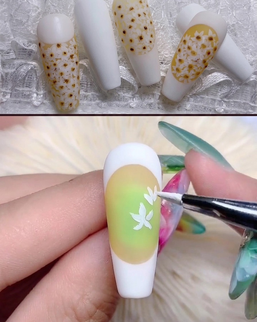 極細ブラシがイエロー調のネイルに白いデイジーの花びらの形を描いている様子。
