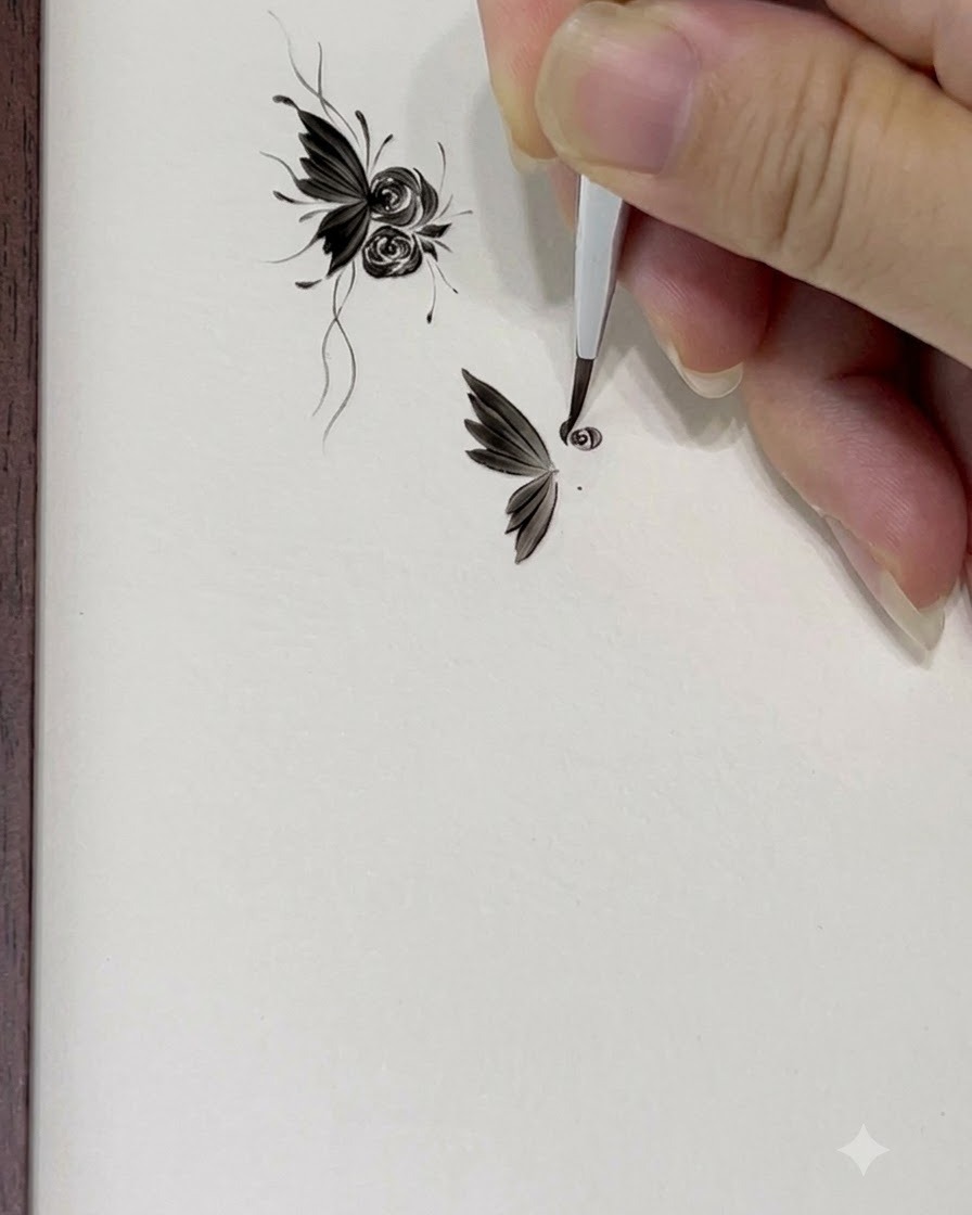 バラの中心をスタートさせるため、極細のティップブラシで「6」の字のような小さなアウトラインを描いているところ。