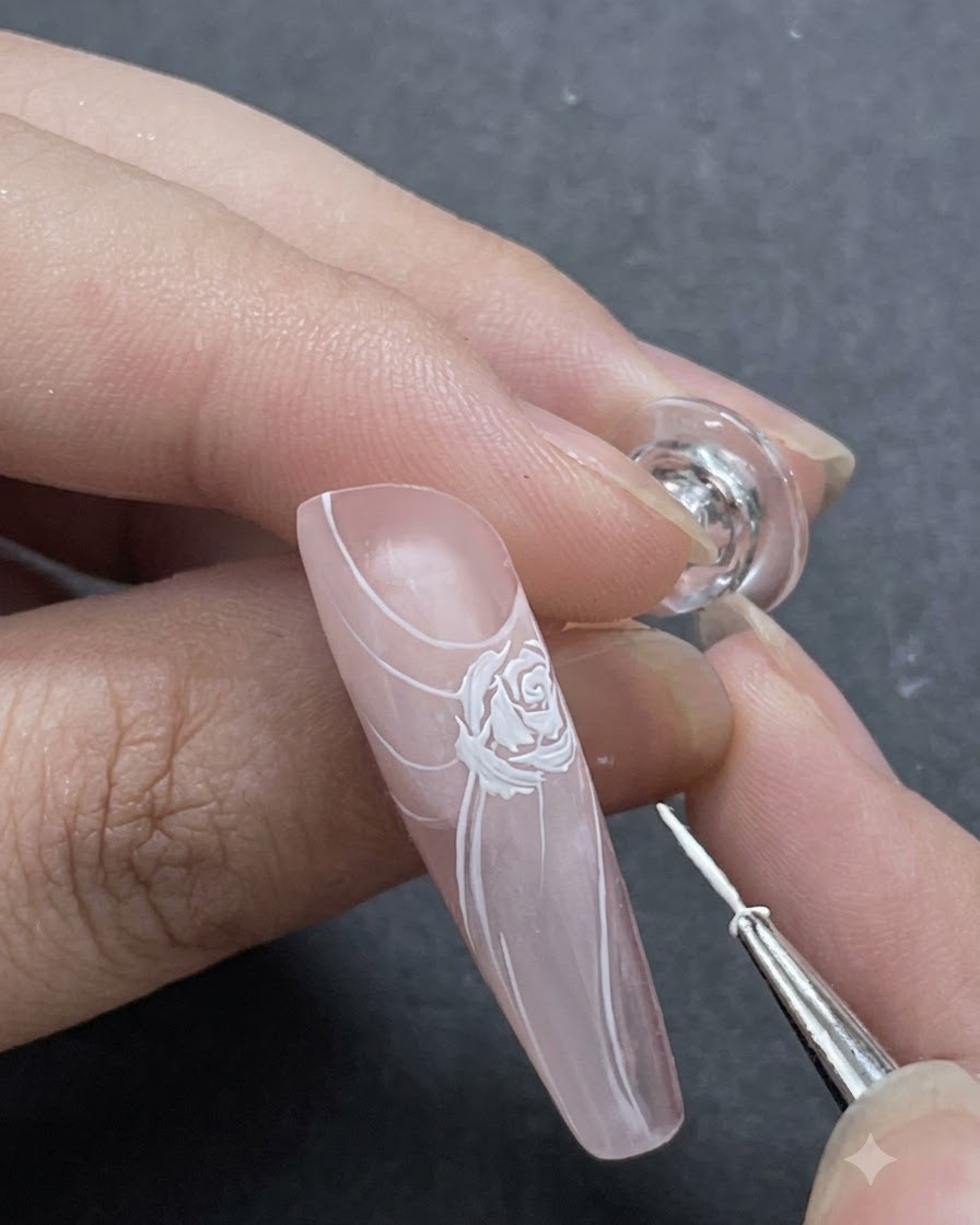 ライナーブラシを使ってメインのバラのデザインの周りに細かい白い花びらのアクセントが加えられているクローズアップショット。