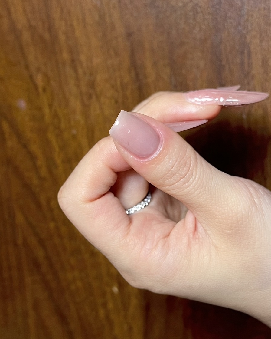 詳細なネイルアートの次のフェーズの準備ができたプレップ済みのヌードネイルを示している手。