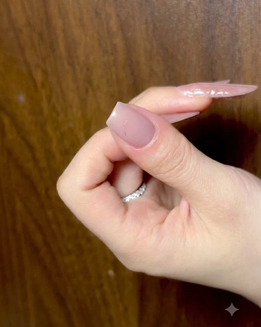 指をわずかに曲げた状態でリラックスしている手で、周囲の照明の下でプレップ済みのヌードネイルを示している様子。