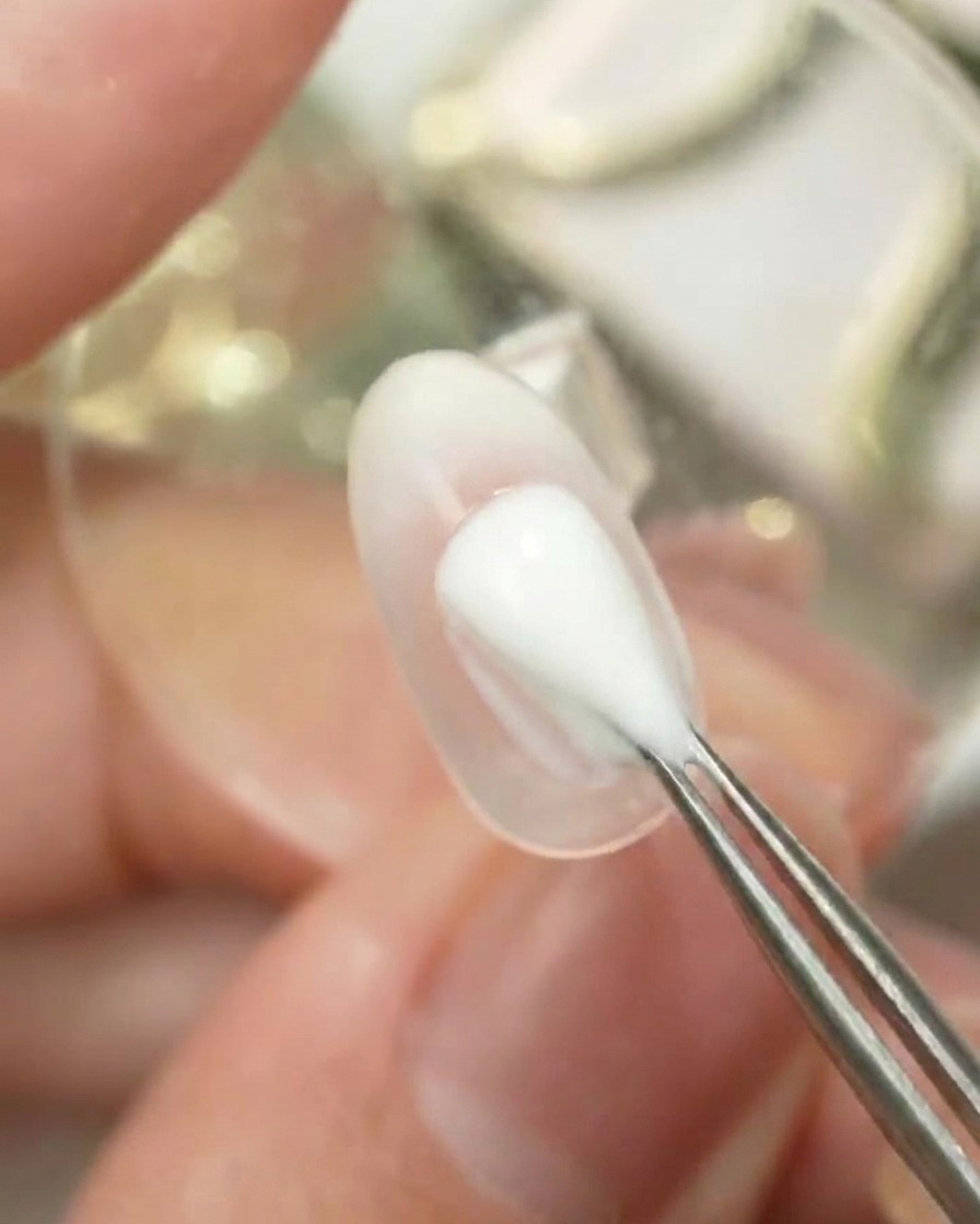 ブレンドツールを使用して、クリアなネイル表面にGulauriパレットカラー番号6をポンポンと置いてオンブレグラデーションを作成している様子。