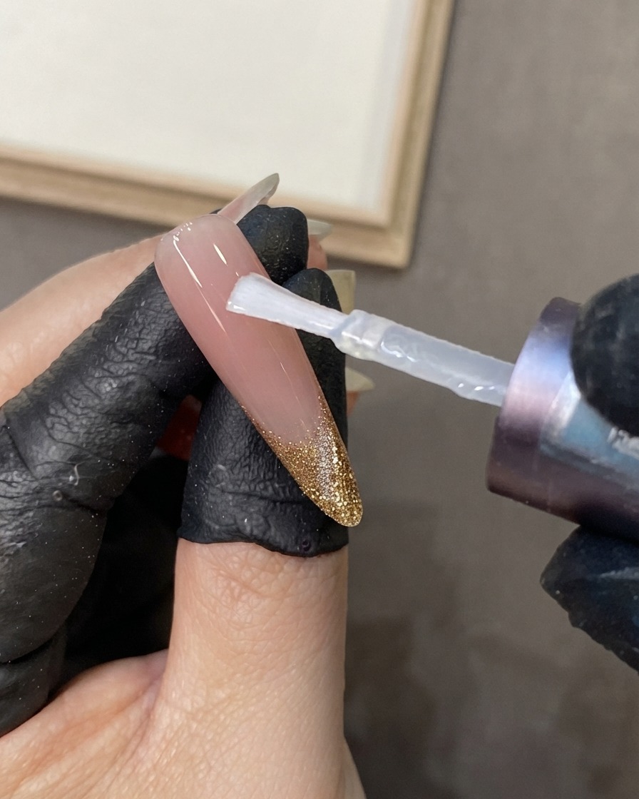 精密なピンセットやツールを使用して、描かれたネイルアートの周囲に細かいダイヤモンドのボーダーラインを配置している様子。