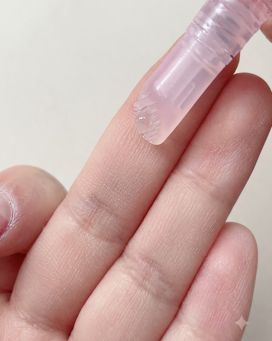 キューティクルペンの柔らかいブラシヘッドから指に保湿美容液のしずくが出されている様子。