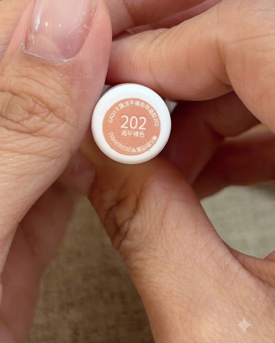 番号202のハニーピーチピンクジェルポリッシュのボトルを手に持っているクローズアップビュー。