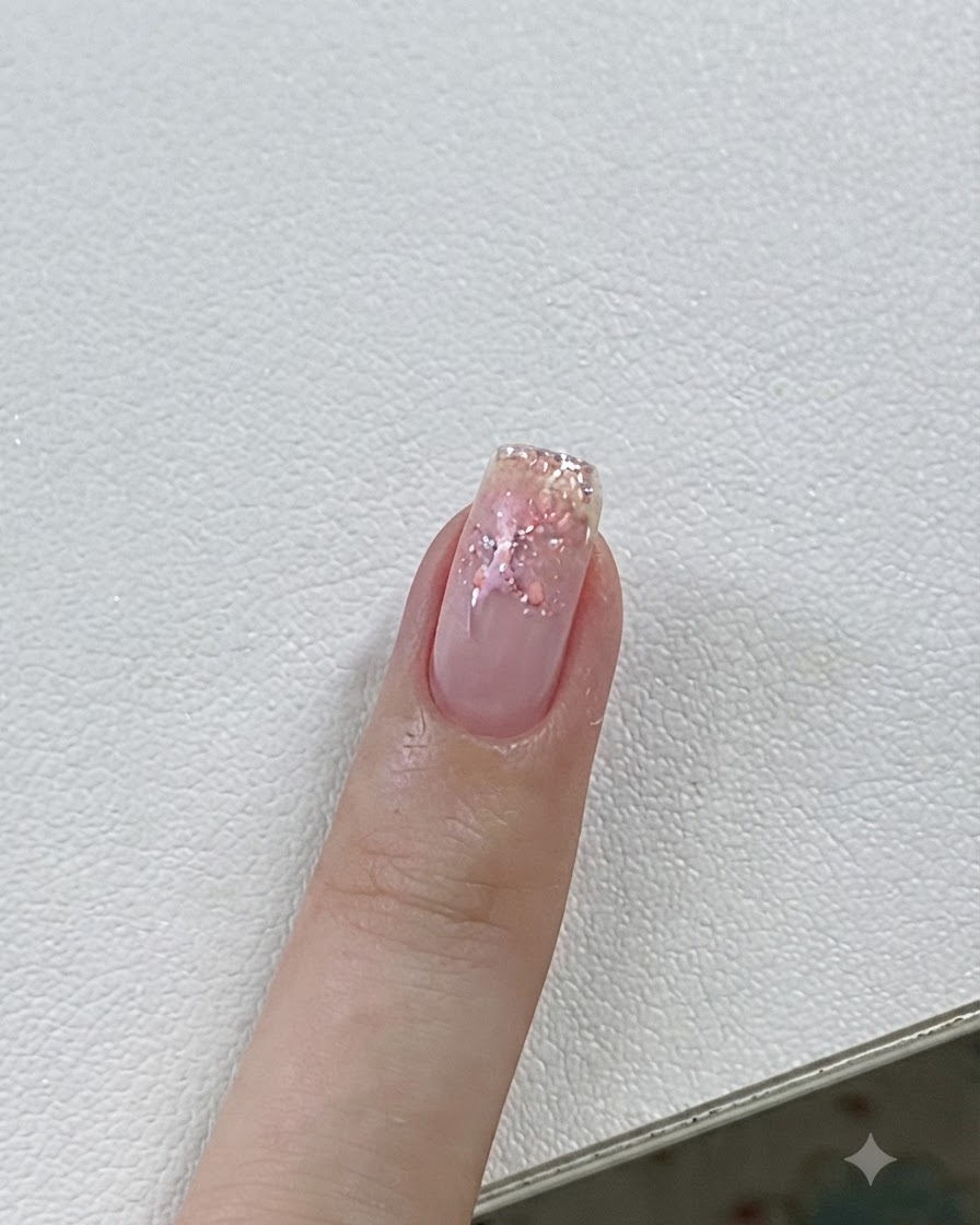 ピンクのジェルと星の詳細を持つ爪が、UV/LEDランプの下で硬化されているクローズアップ。