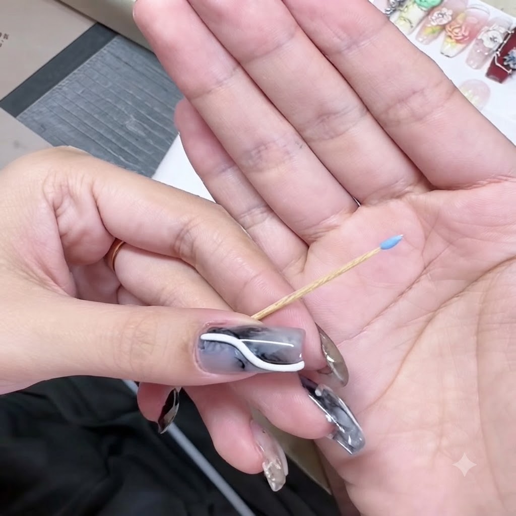 爪楊枝の先端に小さなブルーのジェルの玉をのせた様子。