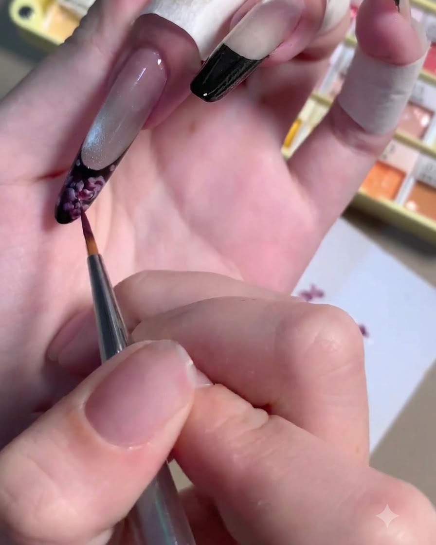 描かれたバラの中心にダークプラムジェルの小さなドットを適用している薄いライナーブラシ。