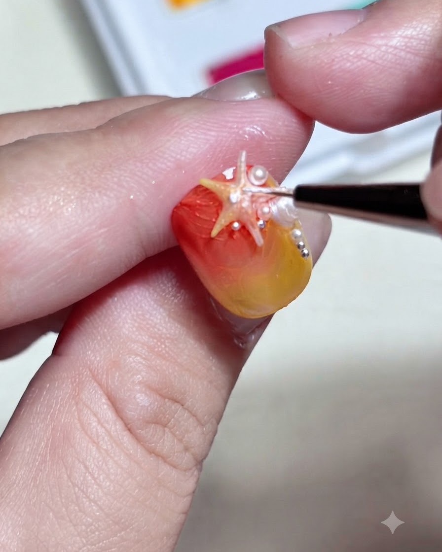 極細のブラシを使い、グラデーションネイルに載せた3Dヒトデパーツの表面に詳細な白いドットやハイライトを描き加えている様子。