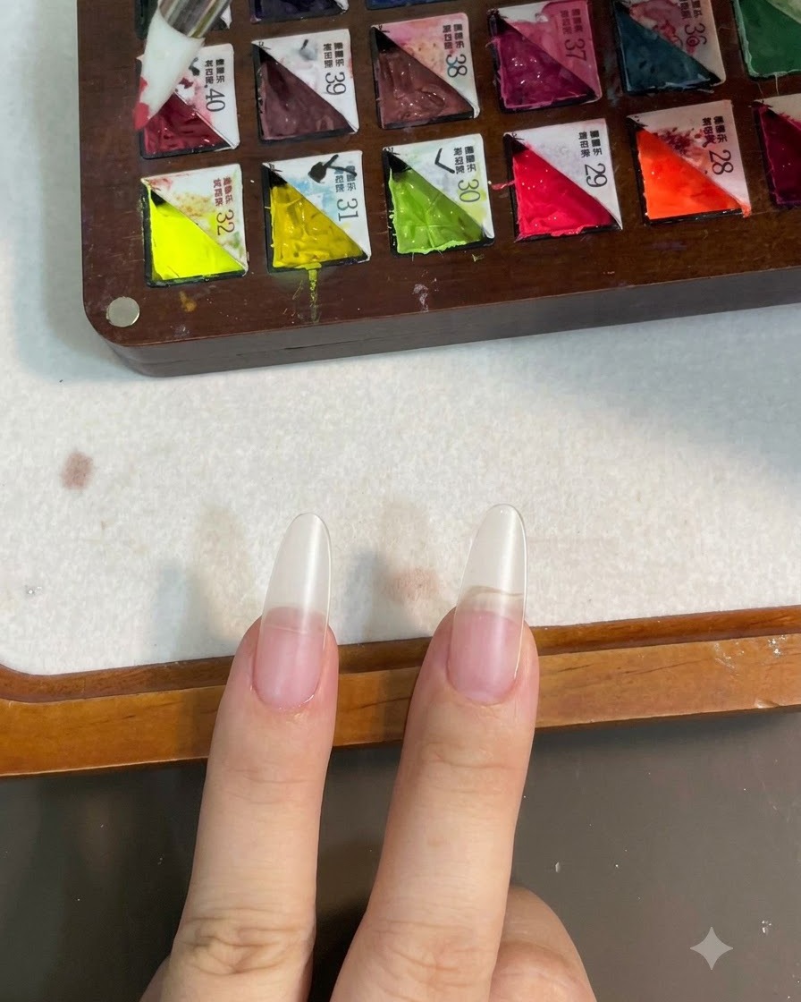 パレットからシリコンブラシでピンクのカラージェルを取っている様子。