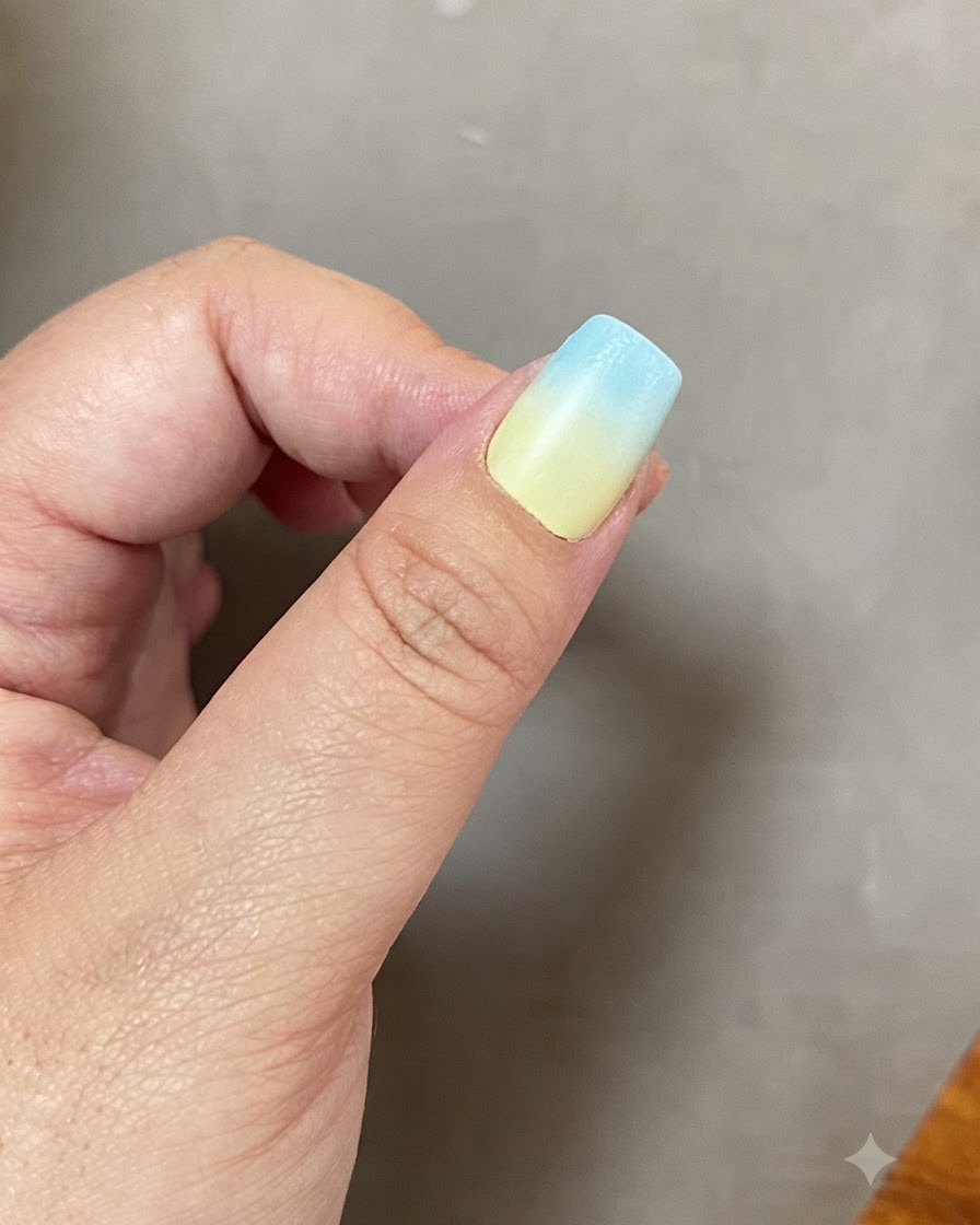 ブルーとイエローのグラデーションの爪をUV LEDネイルライトで硬化している様子。