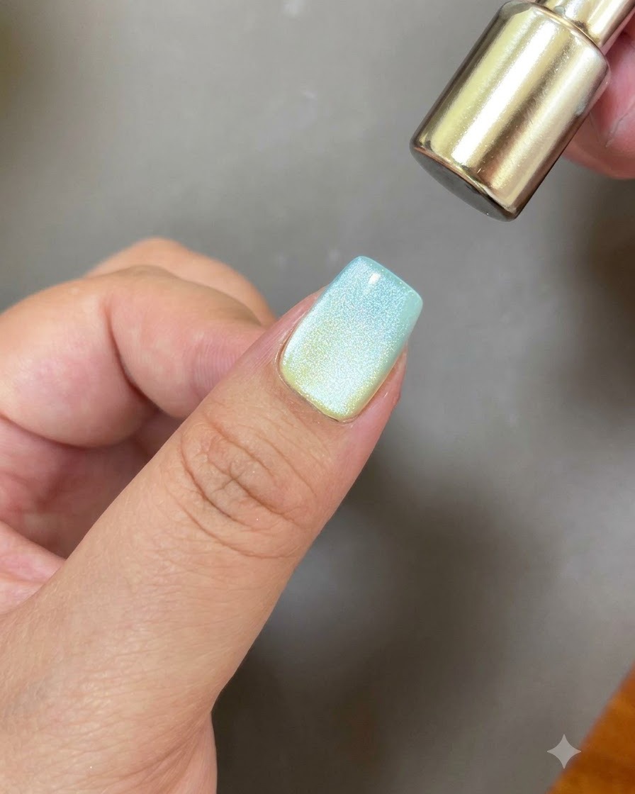 マグネットツールの丸い端を爪の上に浮かせて、円形のキャッツアイの反射を作っている様子。