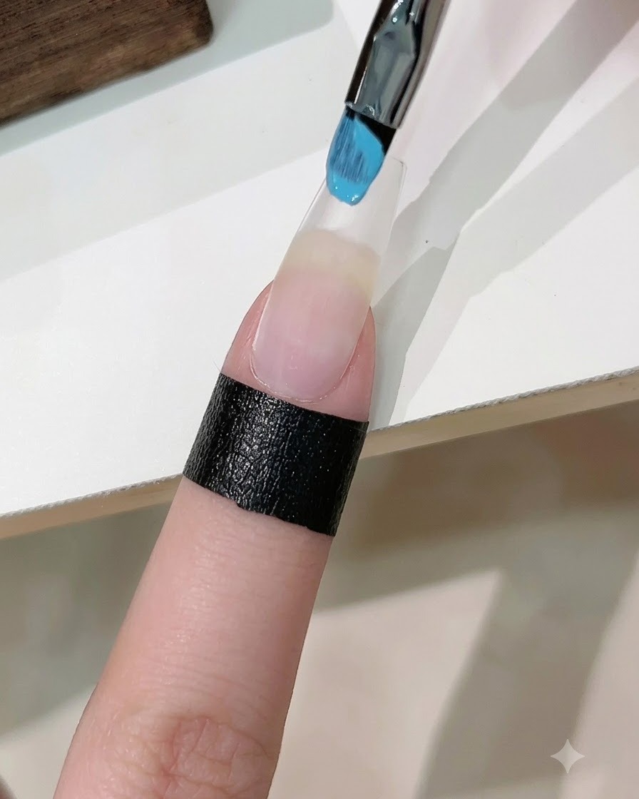 ブルーとホワイトのジェルを含ませたスポンジで、人工爪にグラデーションを作っている様子。