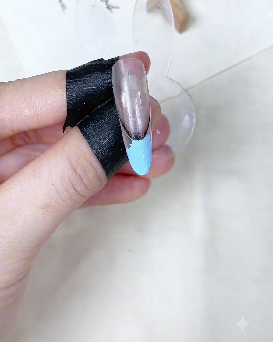 ネイルディスプレイスタンドの上で、ベビーブルーのジェル部分をメイク用スポンジでポンポンと叩いている様子。