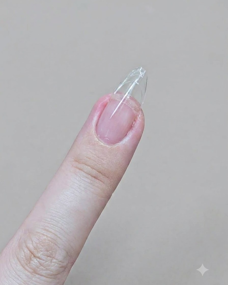 エメリーボードを使ってクリアジェルの先端をすっきりとしたアーモンド型に削っている手元。