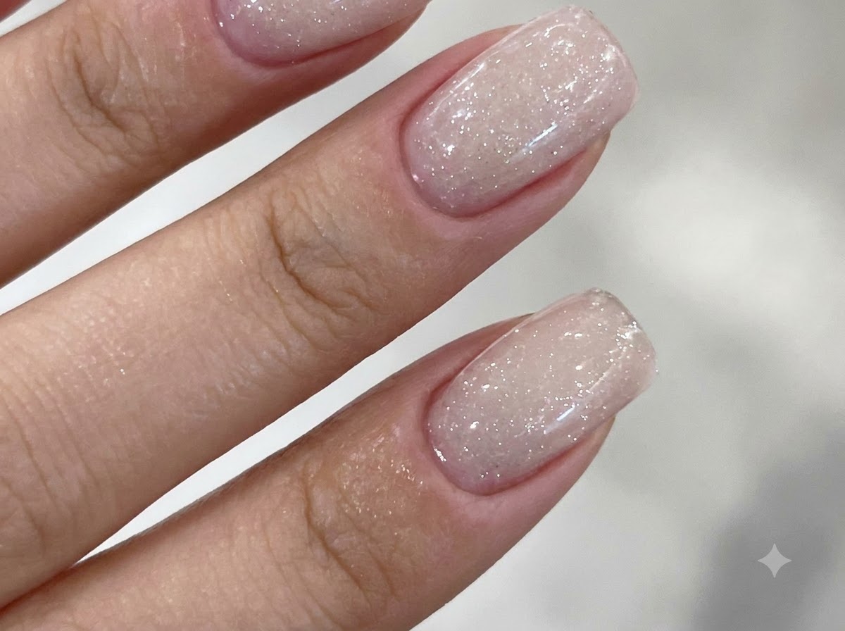 UVまたはLEDライトの中に手を入れて、紫色の光でジェルネイルを硬化している様子。