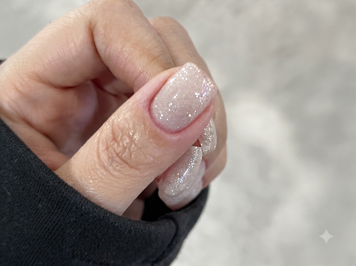 LEDネイルライトの中に手を置き、青い光で指先を照らして硬化させている様子。
