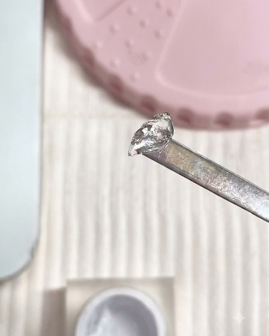 メタルスパチュラが、白を混ぜたPVCソフトキャンディジェルの塊を保持しているところ。