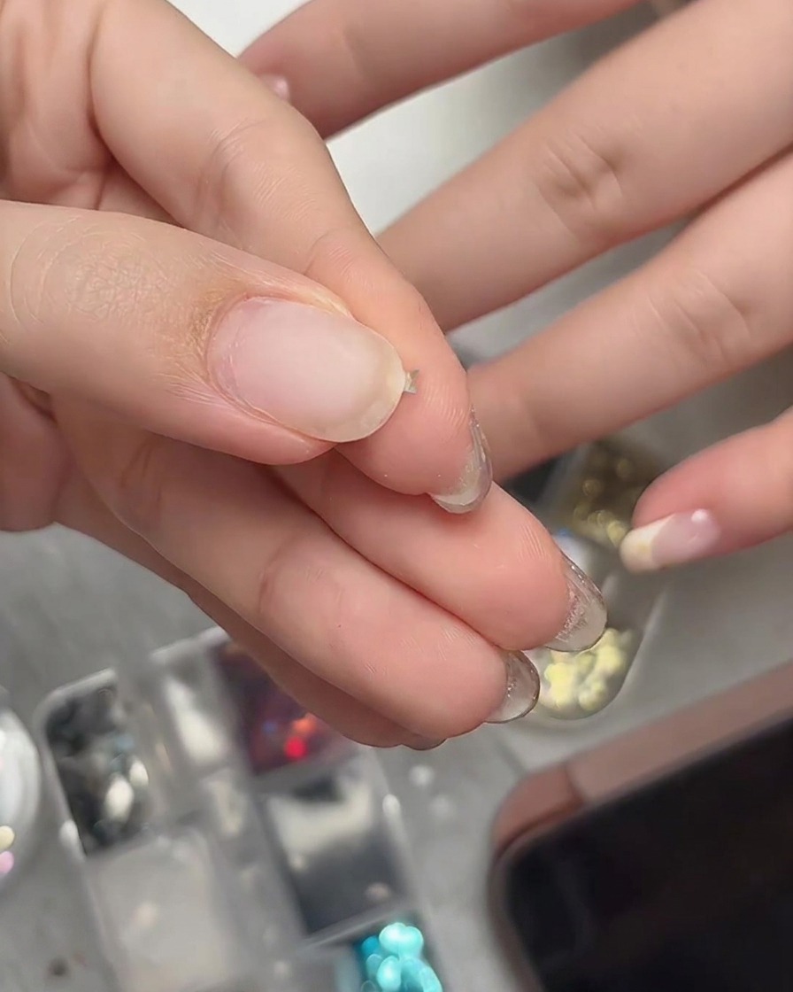 指先で小さな星型グリッターをしっかりとつまんで立体的なカーブ状に曲げている様子。