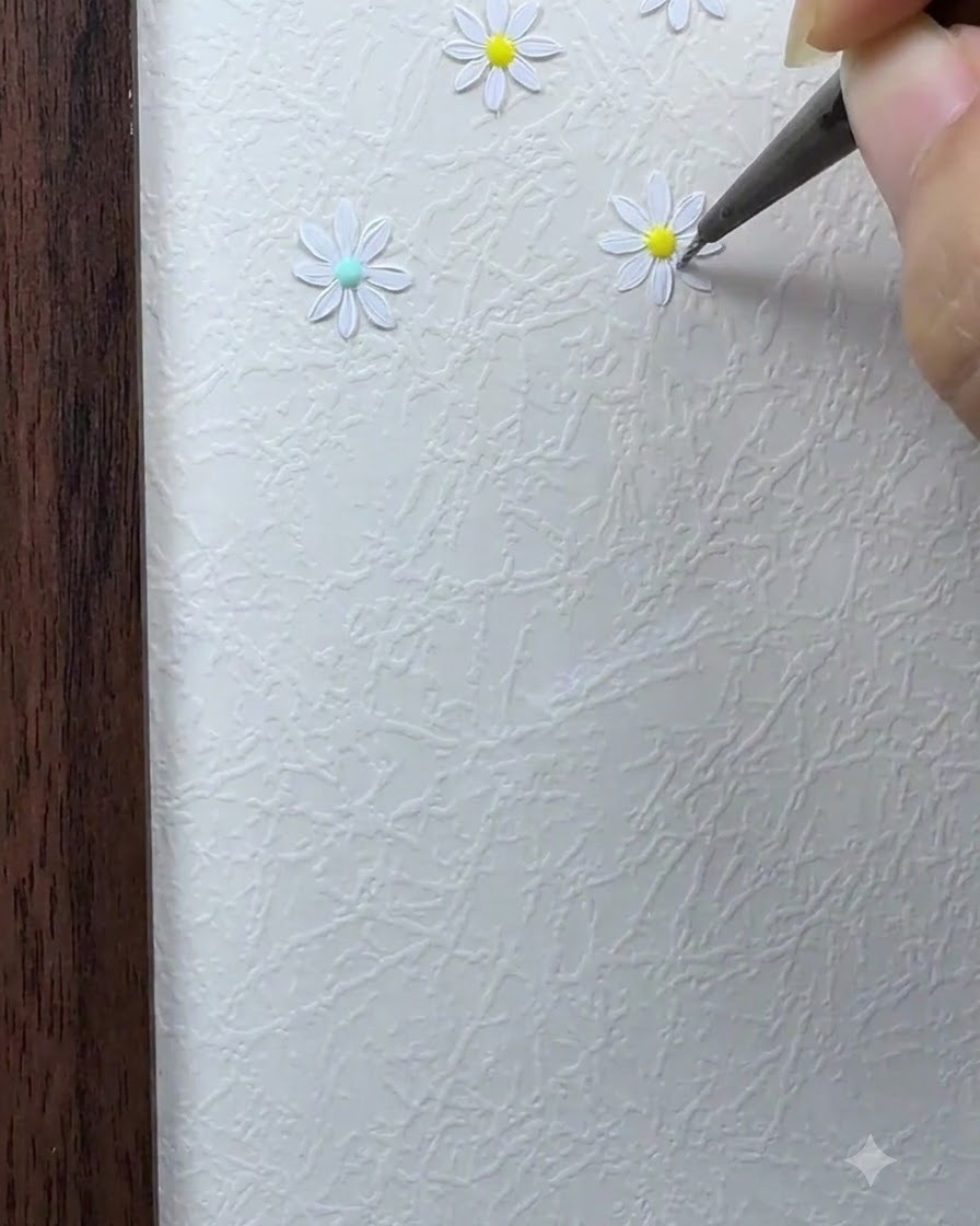 デイジーの花の中心の周りに、細いブラシで残りの白い花びらを埋めているところ。